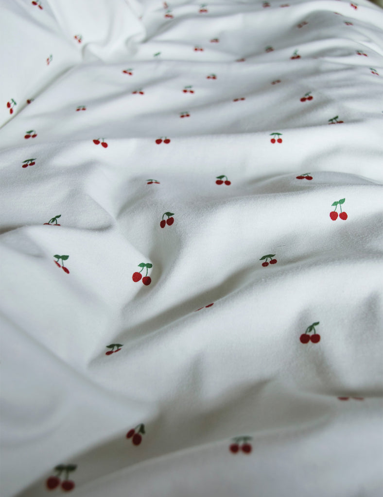 White fabric with small red cherry patterns