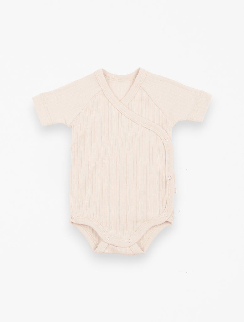 Cotton Ribbed Onesie in Cream flat lay image.