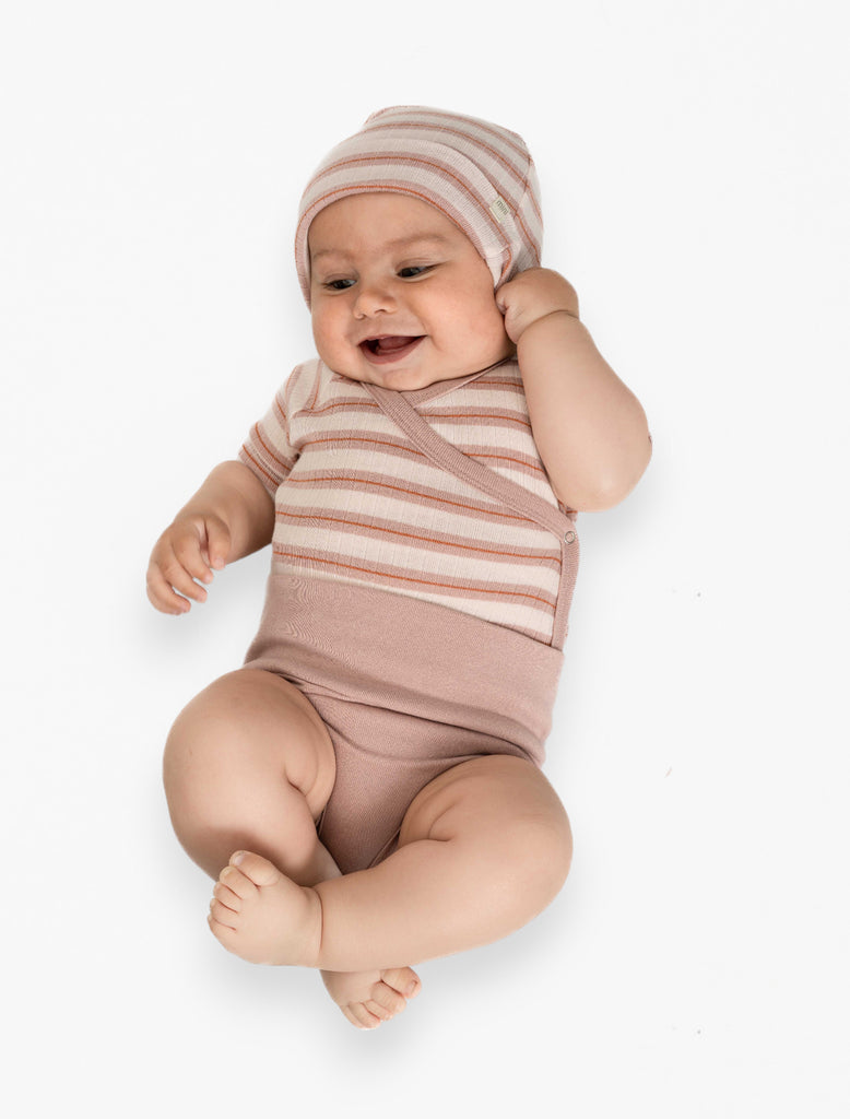 Image of a baby wearing the kimono onesie and beanie in sunset stripes.