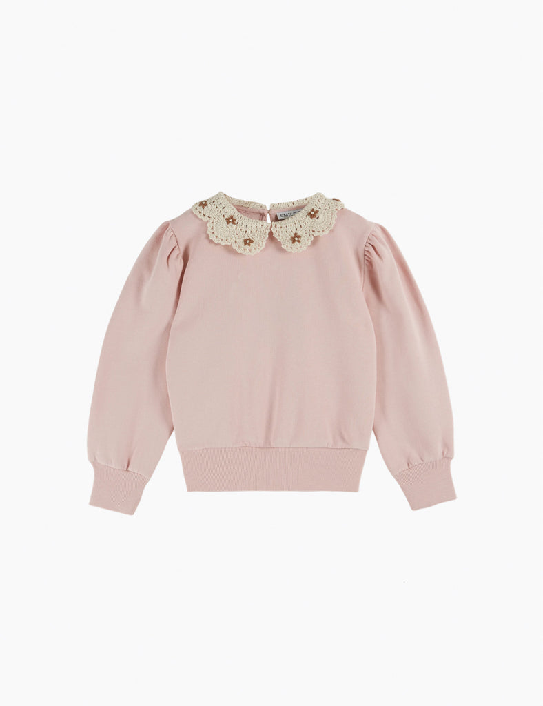 Pink sweater with a decorative collar on a white background