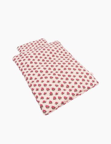 Doll bedding with pink floral pattern on a white background