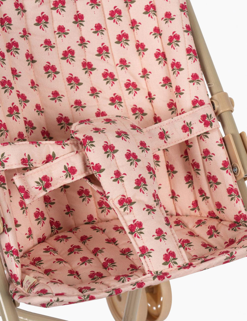 Pink floral patterned fabric on a baby buggy seat cover