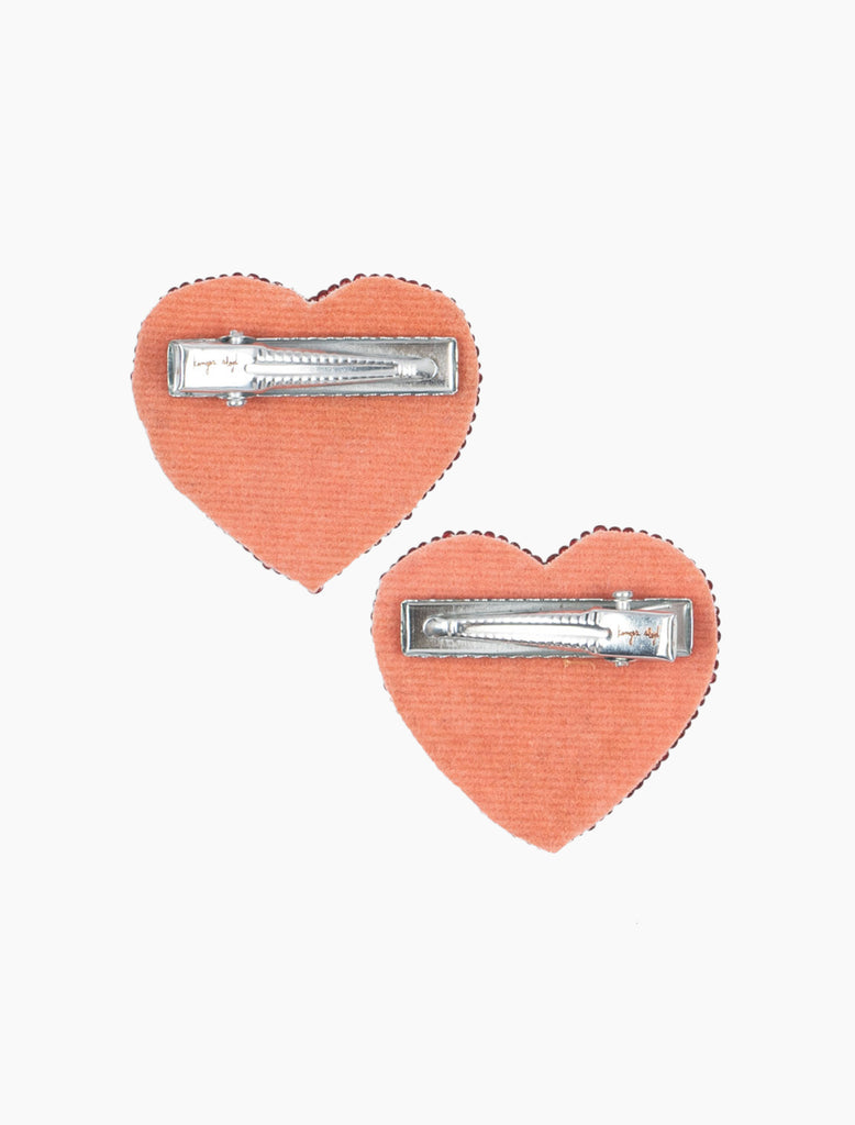 Heart-shaped hair clips with silver bars on a white background