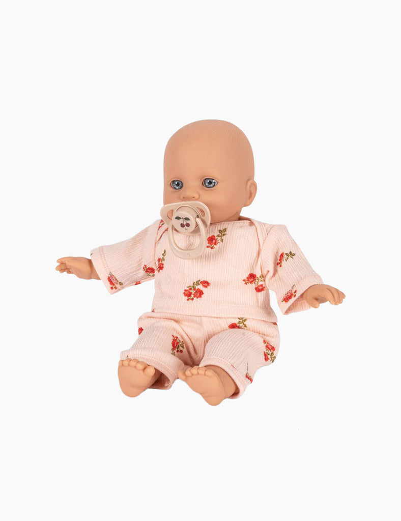 Baby doll wearing a pink outfit with floral patterns on a white background