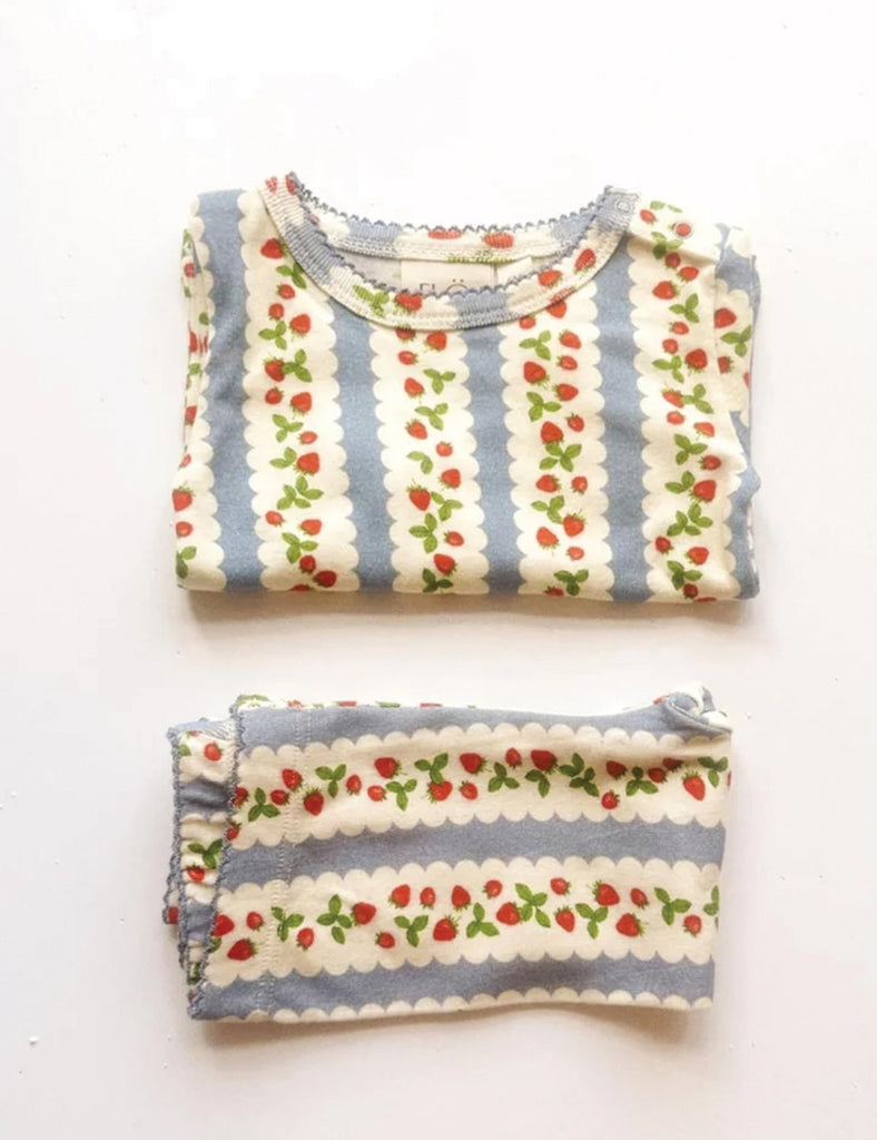 Two folded pieces of clothing with a strawberry pattern on a white background