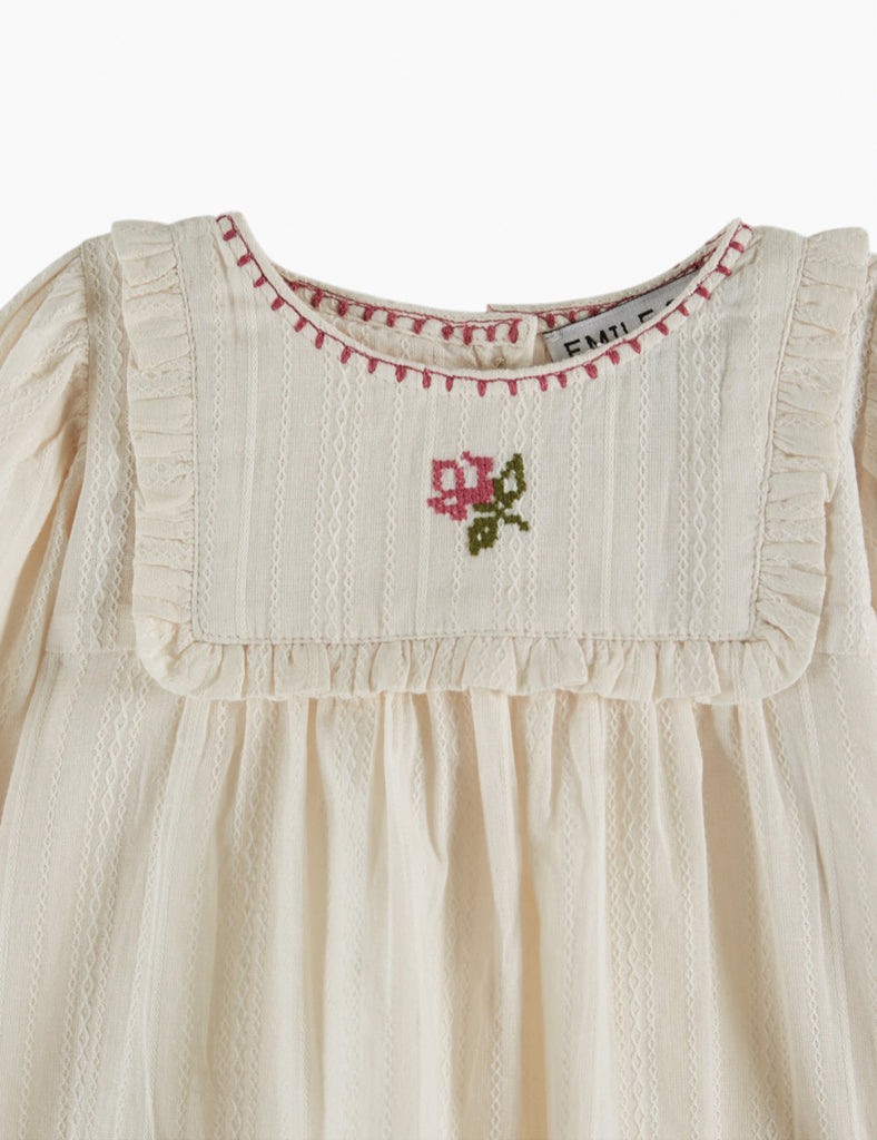 White dress with floral embroidery on a white background