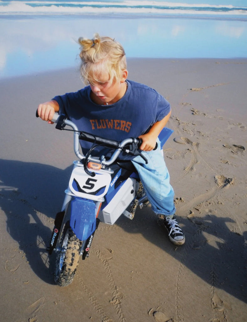 Child on a small bike at the beach