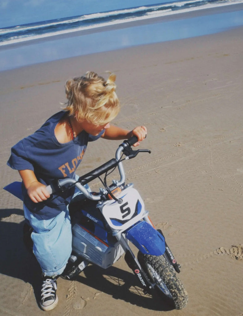 Child on a small bike at the beach