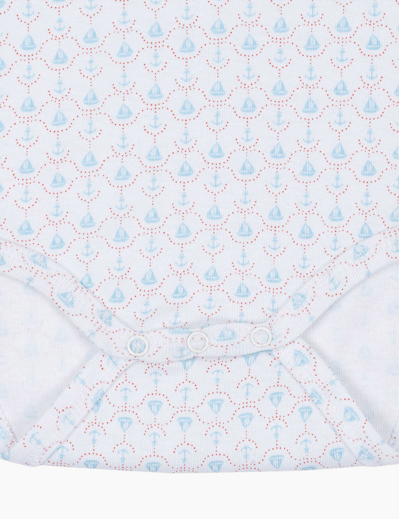 Close up of baby bodysuit with sailboat print.