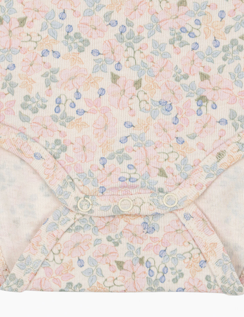 Close up of floral baby bodysuit snap closures.