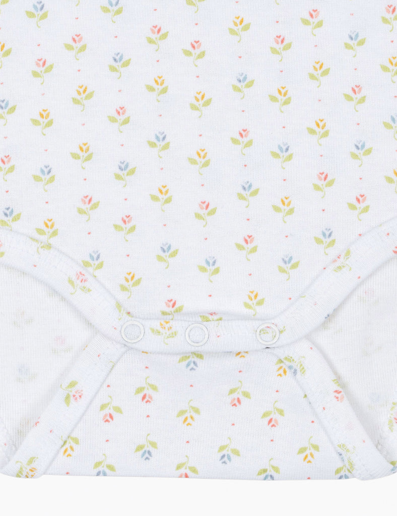 Close up of tulip patterned baby bodysuit on a white background