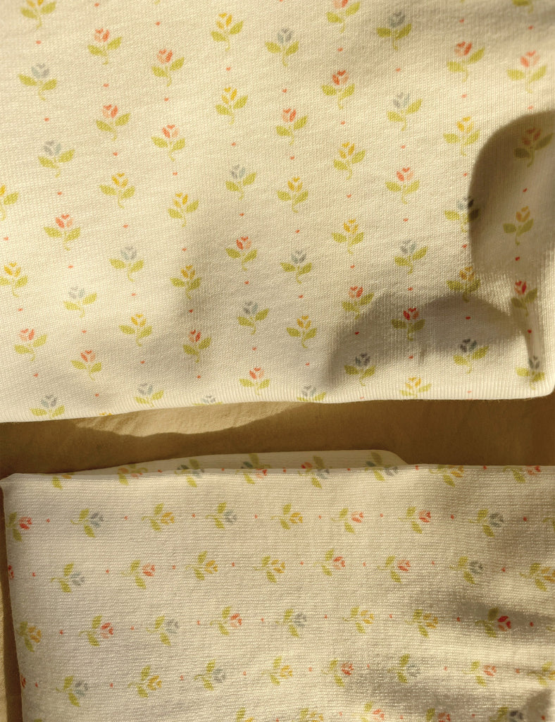 Floral patterned fabric with small flowers on a beige background