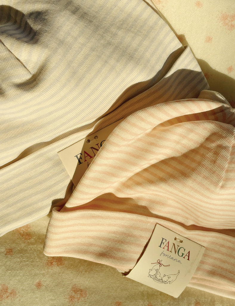 Two baby beanies with a visible brand label on a soft background