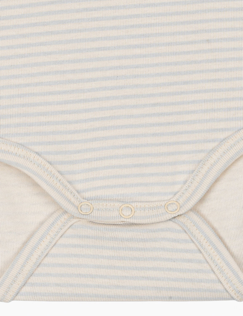 Close-up of a baby outfit with blue and white stripes on a light background