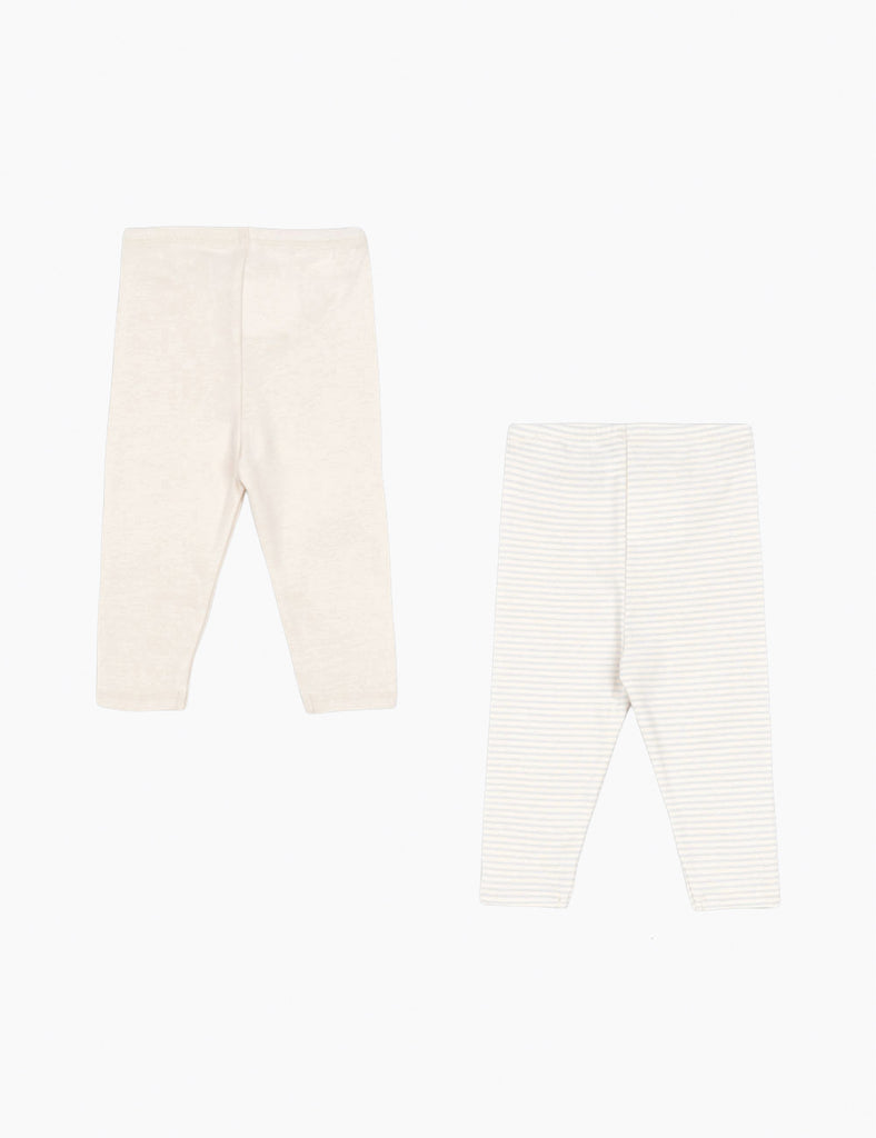 Two pairs of baby leggings, one beige and one white with thin stripes, on a light beige background.