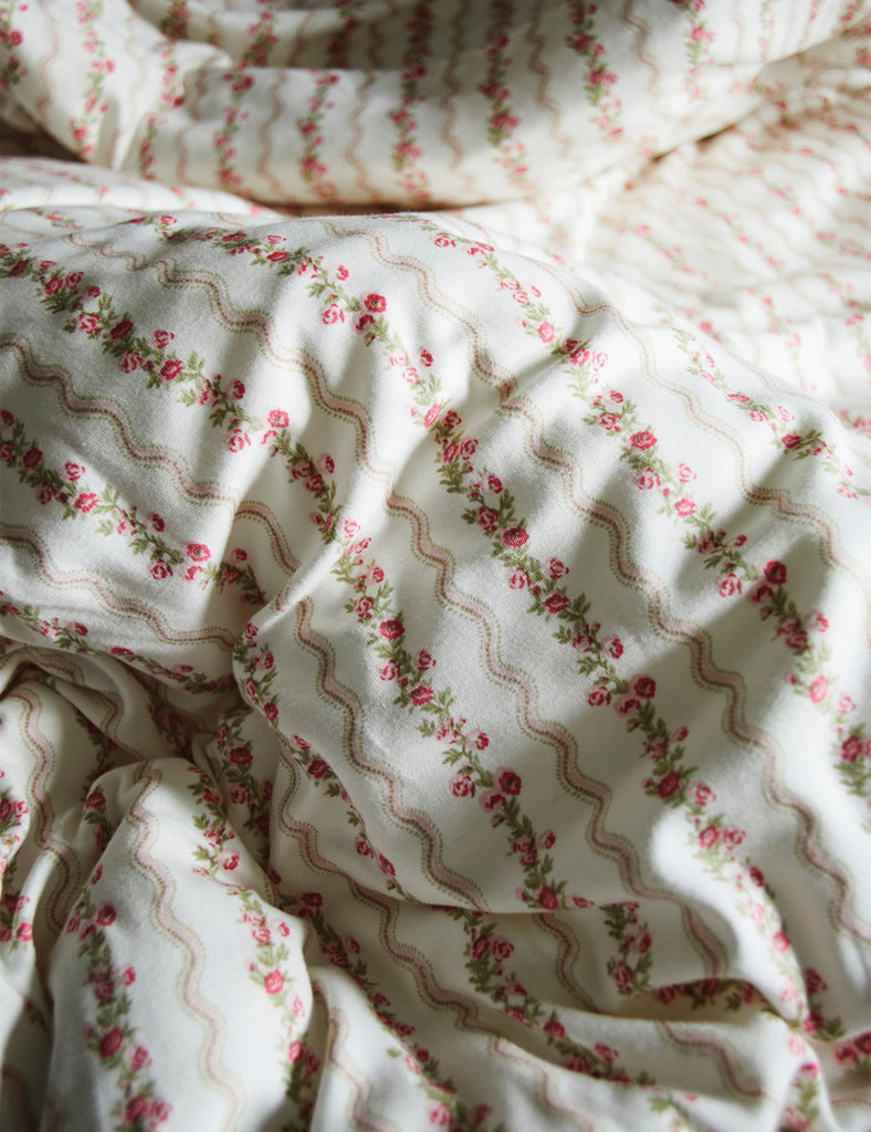 Floral patterned fabric with pink flowers and red outlines on a white background
