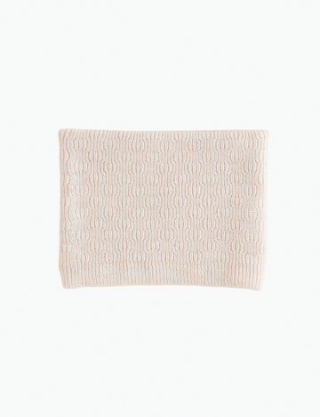 Image of cream colored knitted scarf on a white background.