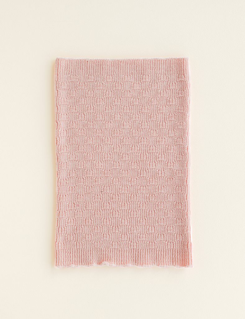 Pink textured blanket on a light beige background