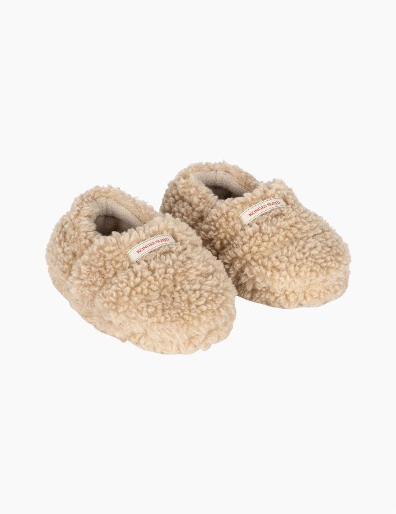 Pair of beige slippers with fuzzy texture on a white background