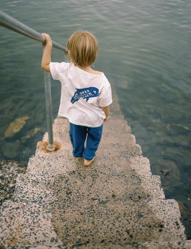 Child walking up a set of stairs by a body of water