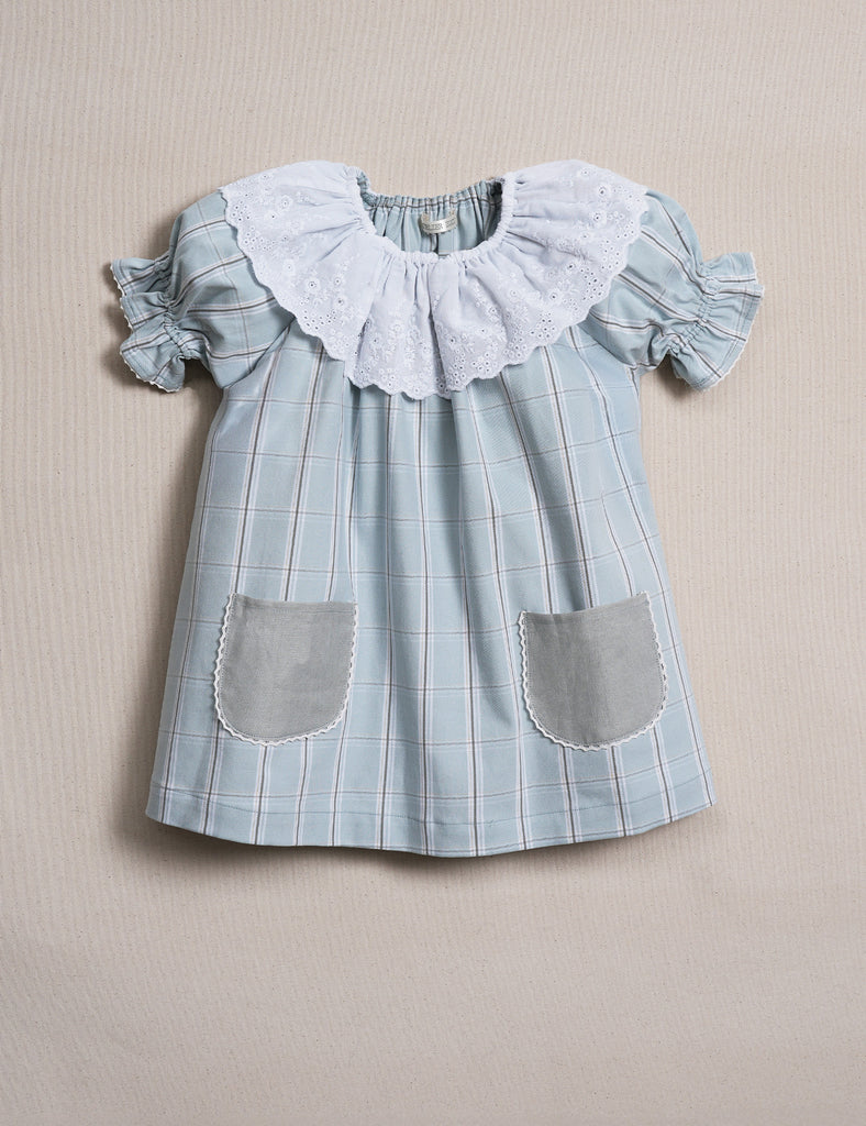 Blue checkered dress with ruffled collar on a beige background