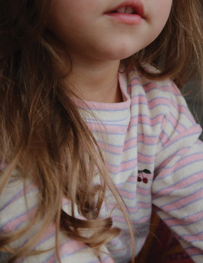 Close-up of a child wearing a striped shirt with a cherry design.