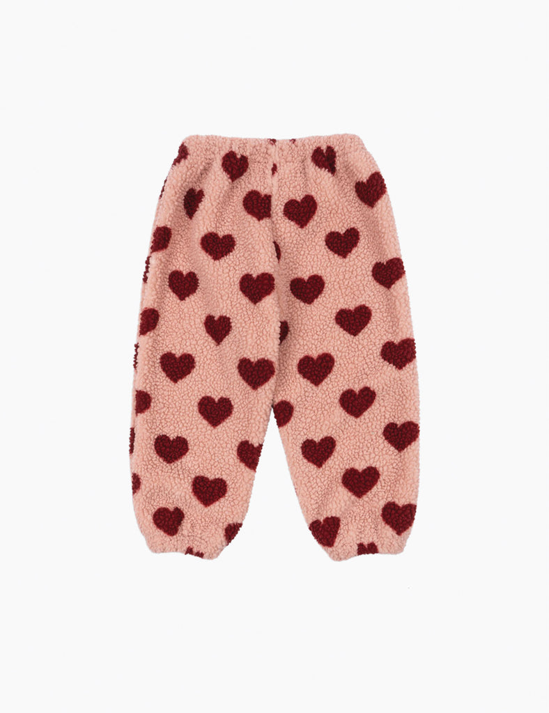 Pink fleece pants with red heart pattern on a white background