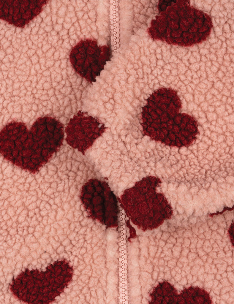 Close-up of a fabric with red heart patterns on a beige background