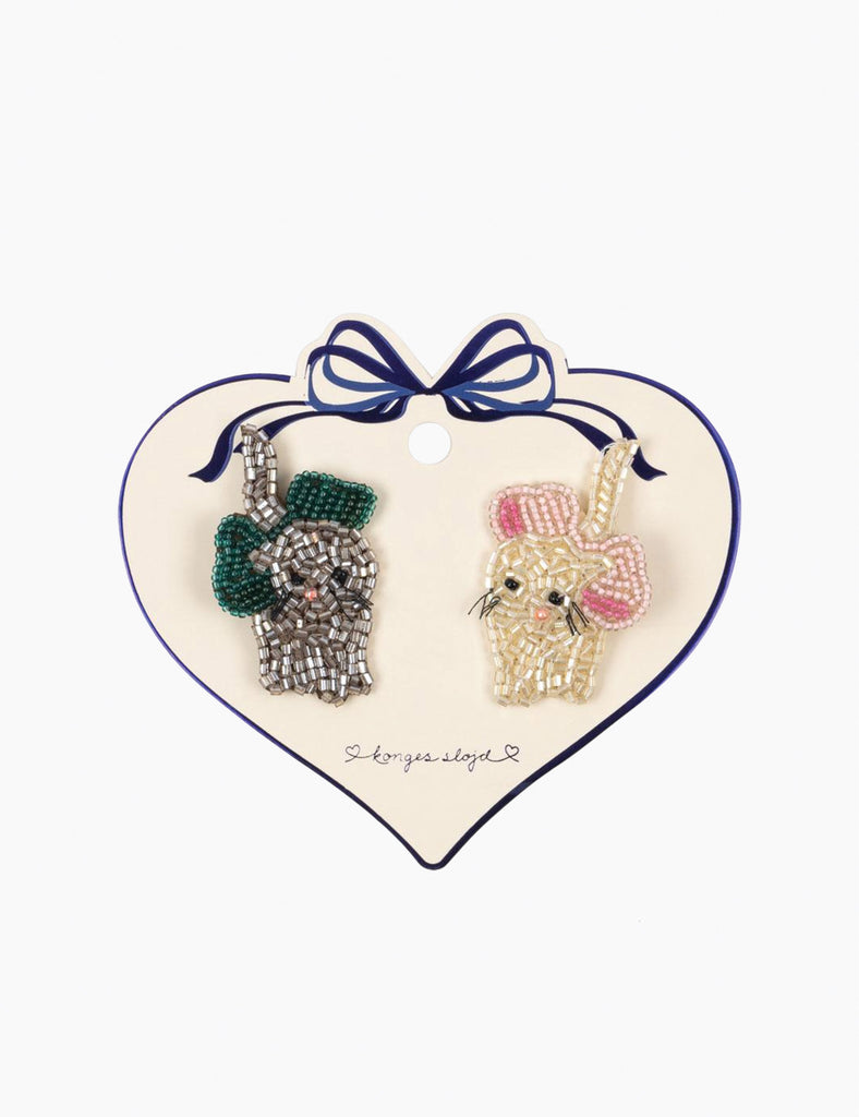 Two decorative hand beaded kitty hair clips on a heart-shaped card with a bow.