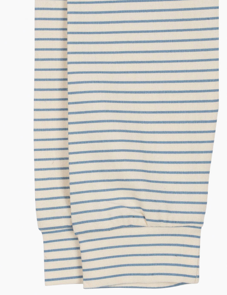 A close up image featuring the bottom of the baby leggings with blue and white stripes on a white background