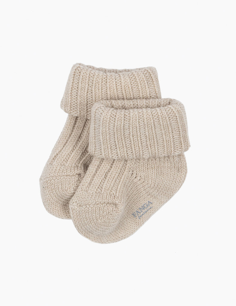 Pair of beige knitted baby socks on a white background