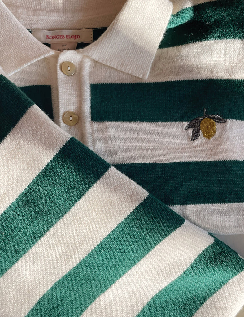 Close-up of a green and white striped polo shirt with a brand label.