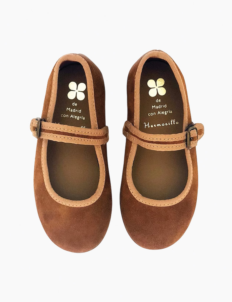 Image of Mary Janes in a camel suede color on a white background.