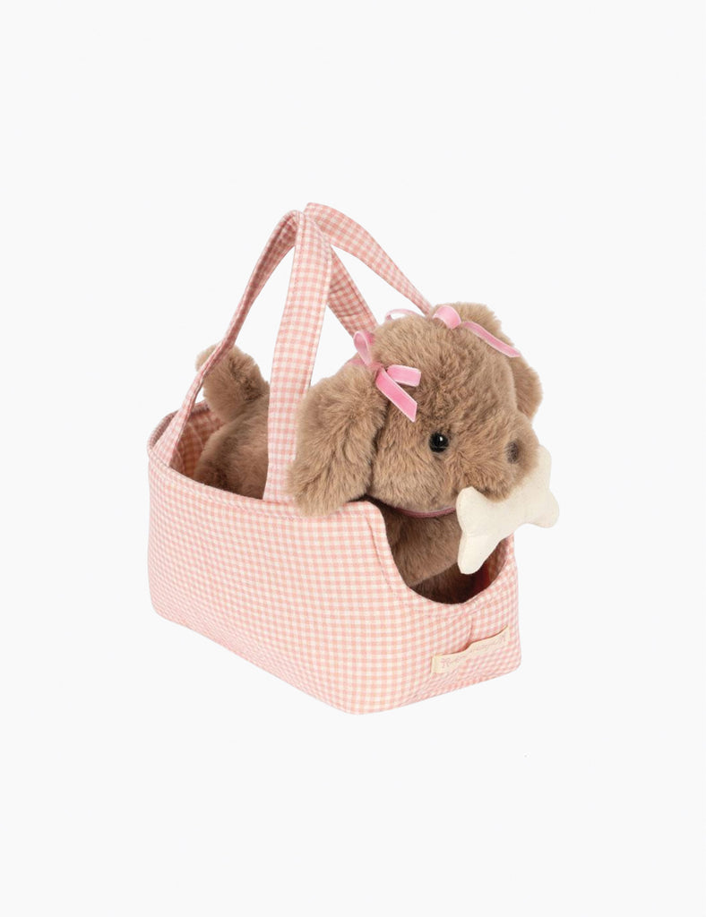 Plush dog toy with a pink bow in a pink basket on a white background