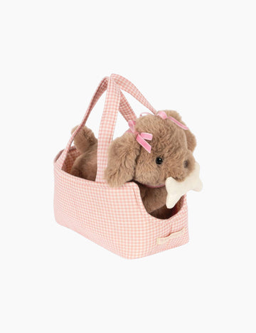 Plush dog toy with a pink bow in a pink basket on a white background