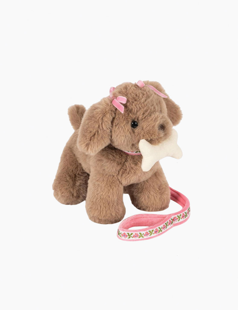 Plush dog toy with a pink leash on a white background