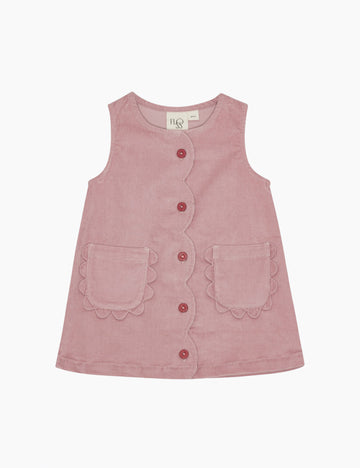 Pink sleeveless dress with buttons and scalloped edges on a white background
