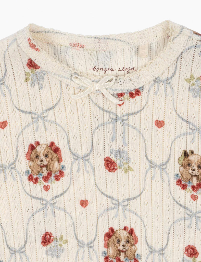 Baby outfit with dog and flower pattern on a white background
