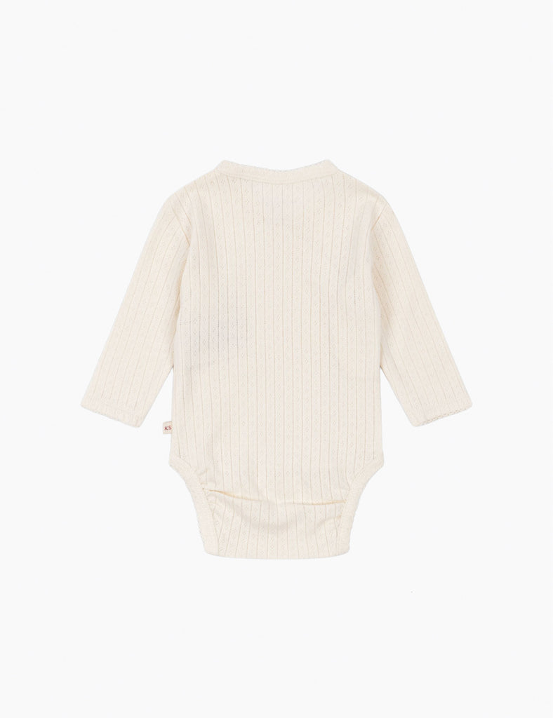 White ribbed baby onesie on a white background