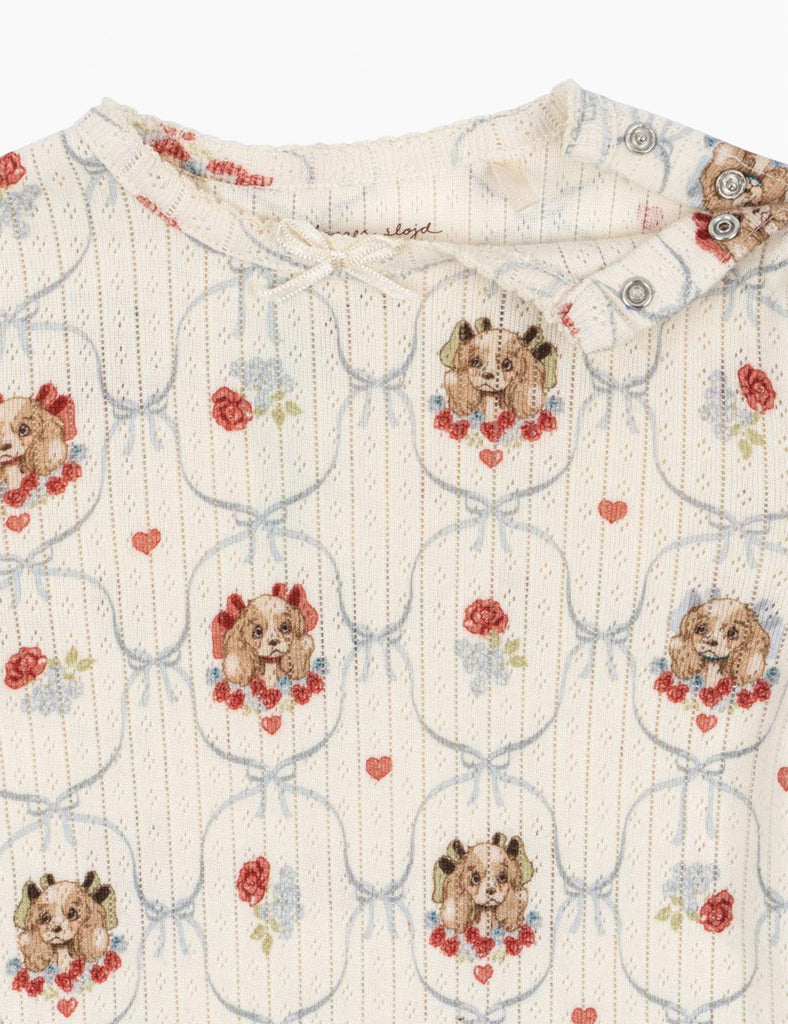 Baby onesie with puppy and floral pattern on a white background