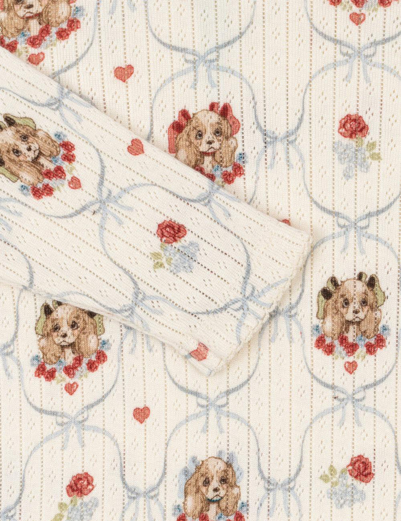 Close up of puppy patterned baby onesie on a white background