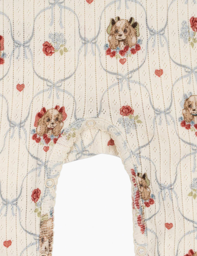 Patterned fabric with puppies and flowers on a white background