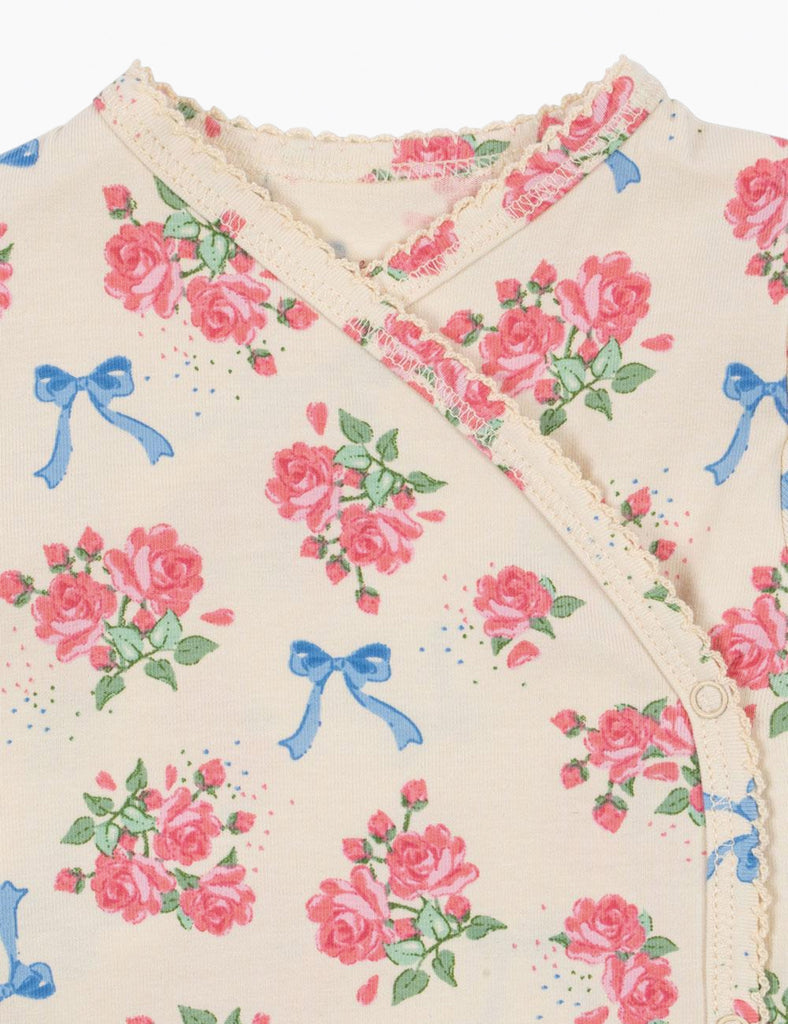 Floral patterned fabric with pink roses and blue bows on a beige background