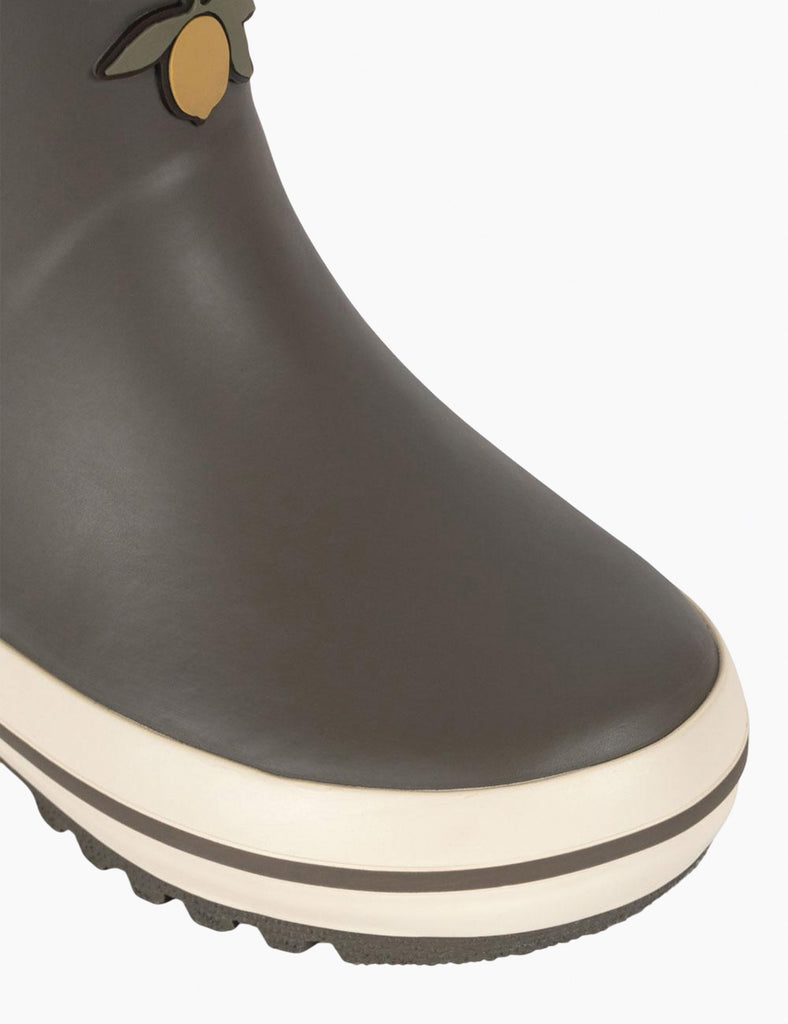 Dark gray rain boot with a white sole on a light gray background