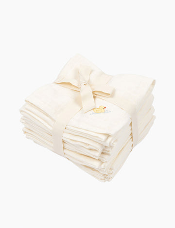 Stack of white muslin baby cloths with a decorative bow on a white background