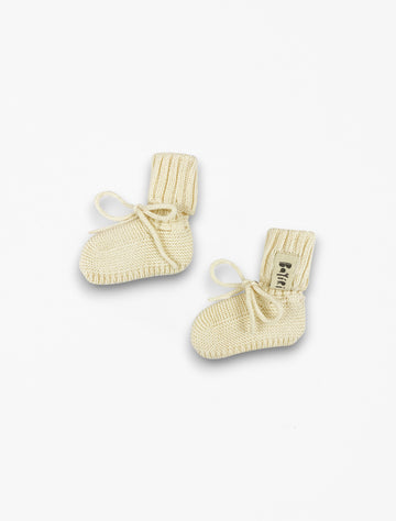 Orion baby booties in milk flat lay image.