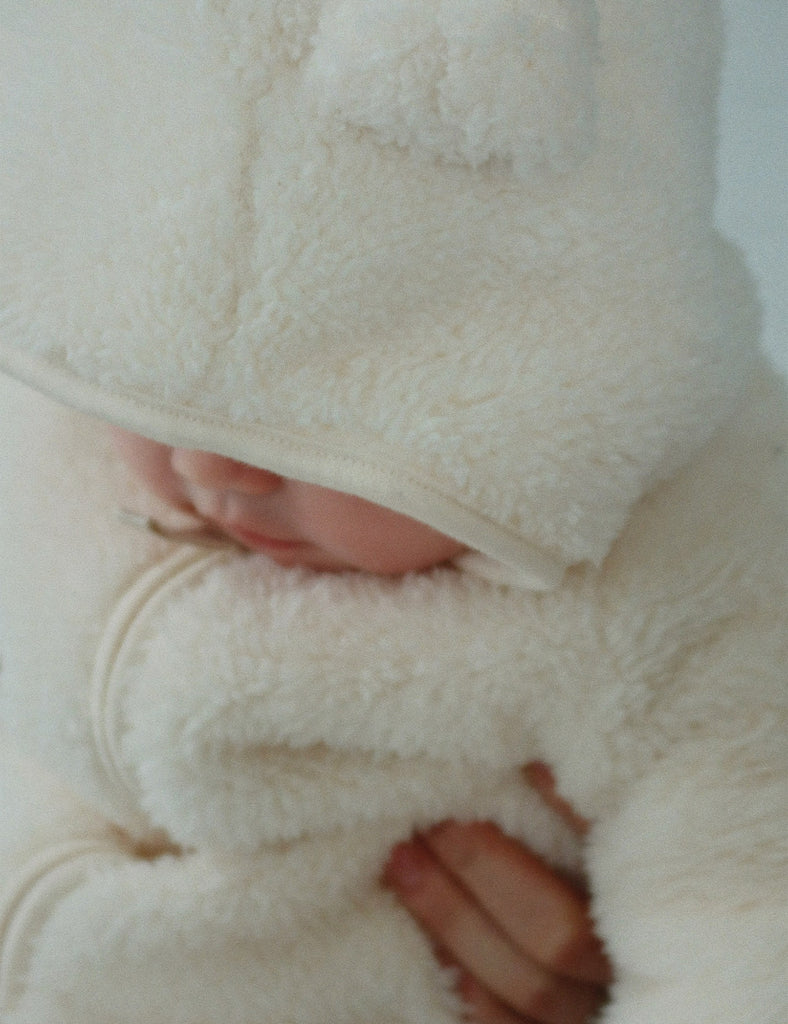 Close-up of a baby wrapped in a white blanket