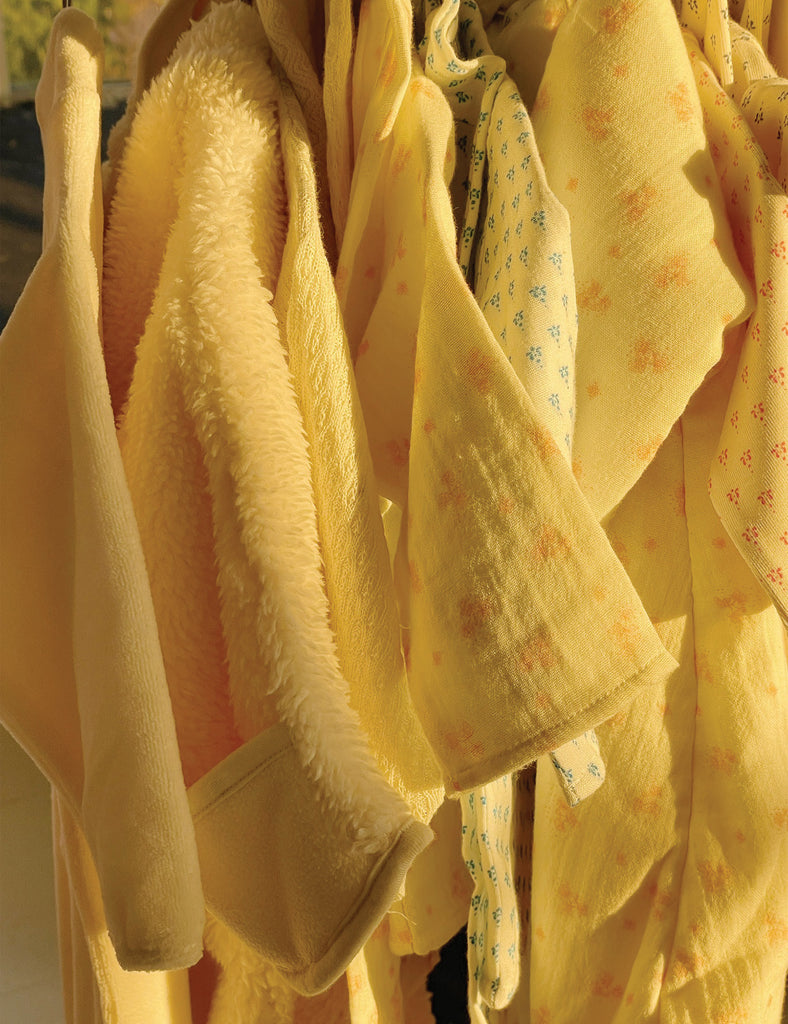 Yellow baby blankets with floral patterns hanging together