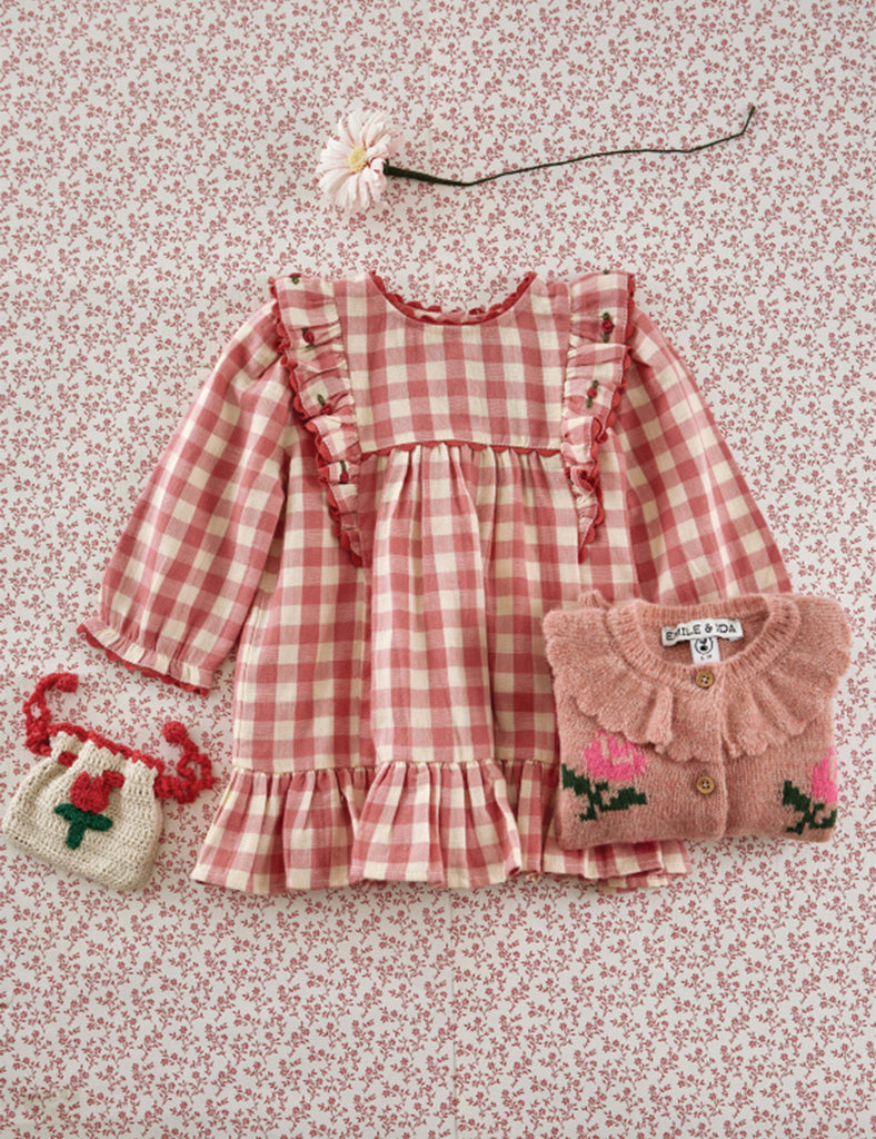 Pink checkered dress with matching accessories on a floral background