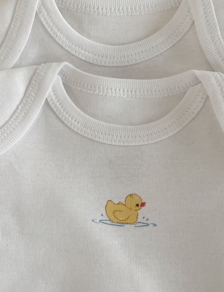 White baby onesie with a yellow rubber duck design on a white background
